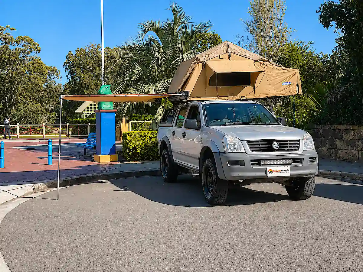 Auto mit Dachzelt und geöffneter Markise bei Travelwheels Campervans