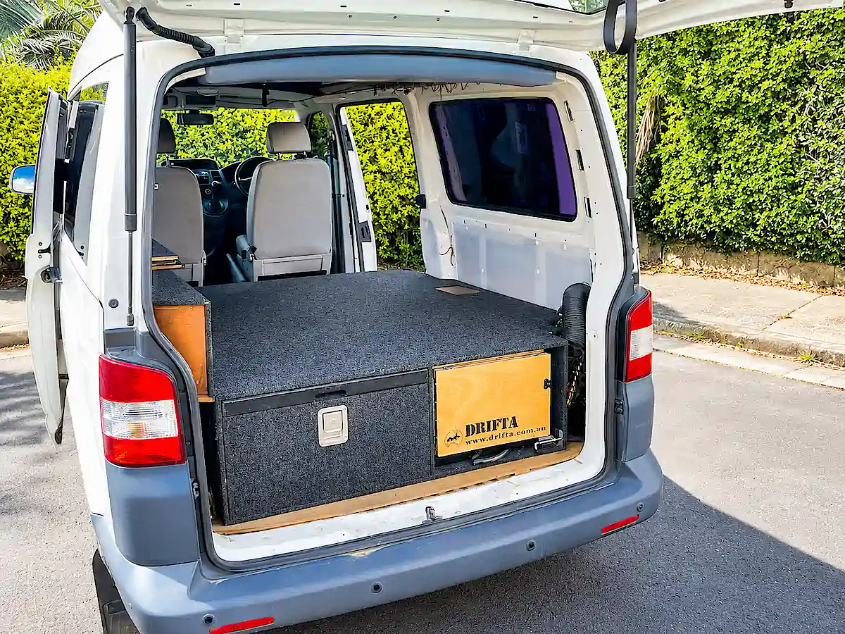 VW Camper kaufen in Sydney bei Travelwheels – Heckansicht mit Bett und großem Stauraum